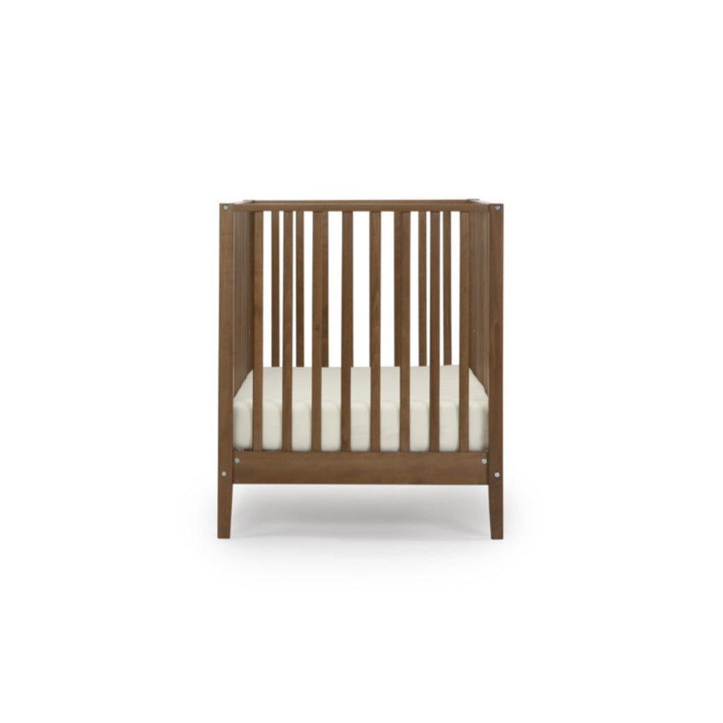 Side view of Dadada Lala 3-in-1 Convertible Crib in - Color_Walnut