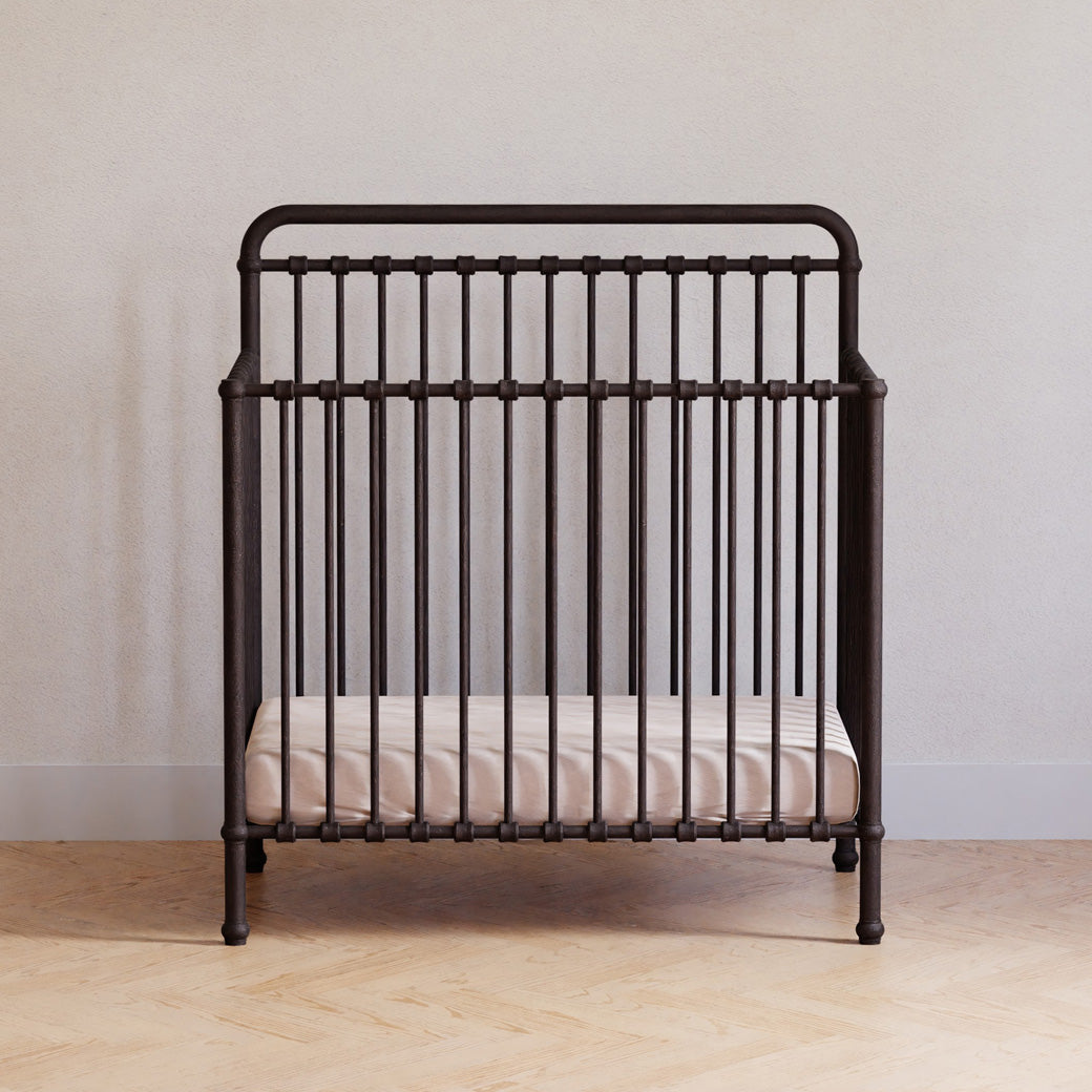 Front view of Namesake's Winston 4-in-1 Convertible Mini Crib in a room in -- Color_Vintage Iron