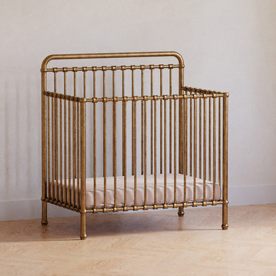 Namesake's Winston 4-in-1 Convertible Mini Crib in a room in -- Color_Vintage Gold