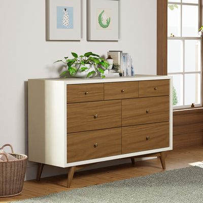 Babyletto's Palma 7-Drawer Assembled Double Dresser next to a window in -- Color_Warm White with Natural Walnut