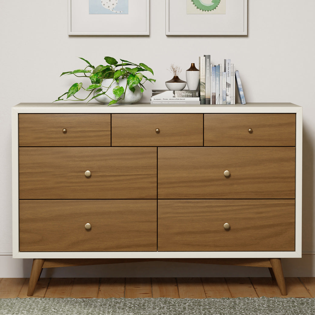Front view of Babyletto's Palma 7-Drawer Assembled Double Dresser with items on top in -- Color_Warm White with Natural Walnut