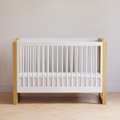 Front view of Namesake's Nantucket 3-in-1 Convertible Crib in a room in -- Color_Warm White/Honey