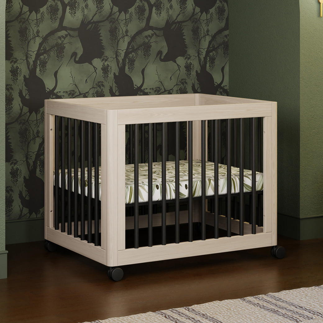 Babyletto's Yuzu 8-In-1 Convertible Crib With All Stages Conversion Kits as midi crib in a green-wallpaper room  in -- Color_Washed Natural / Black