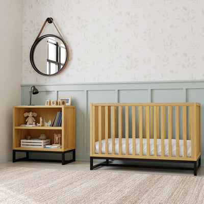 DaVinci's Ryder Convertible Cubby Changer & Bookcase next to a crib in -- Color_Honey