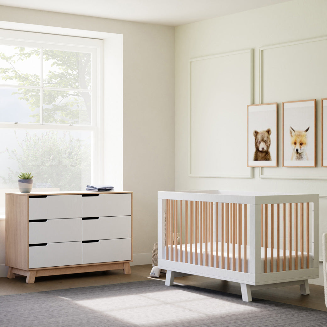 Babyletto Hudson 3-in-1 Crib next to a dresser and window in -- Color_Washed Natural/White