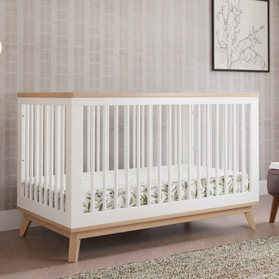 Babyletto's Scoot 3-in-1 Convertible Crib + Toddler Rail next to a picture  in -- Color_Washed Natural/White