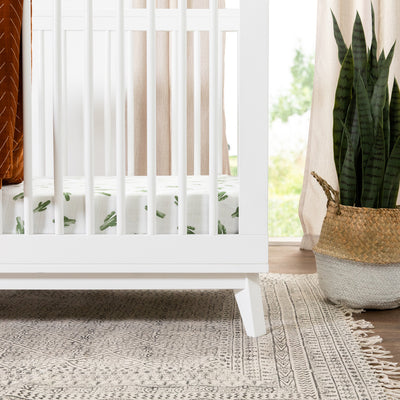 Closeup of Babyletto's Scoot 3-in-1 Convertible Crib next to a plant  in -- Color_White