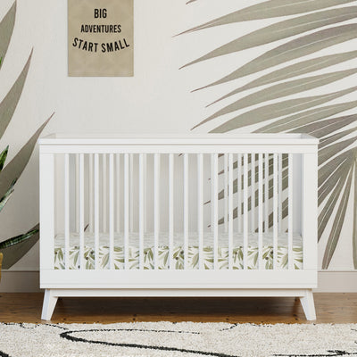 Front view of Babyletto's Scoot 3-in-1 Convertible Crib under a wall hanging  in -- Color_White
