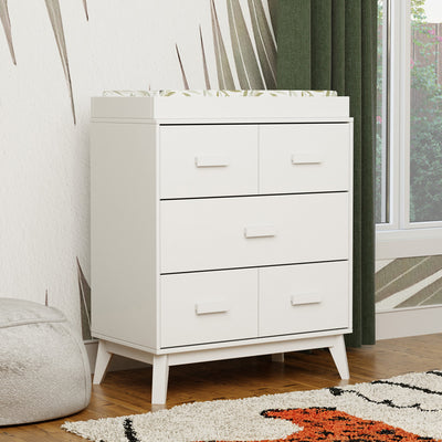 Babyletto's Scoot 3-Drawer Changer Dresser next to a window  in -- Color_White