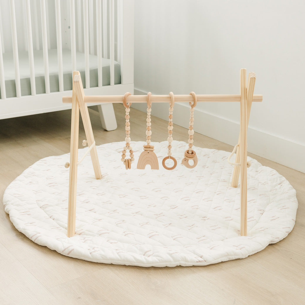 Poppyseed Play Wood Baby Gym + Toys on a mat in -- Color_Natural _ Wood