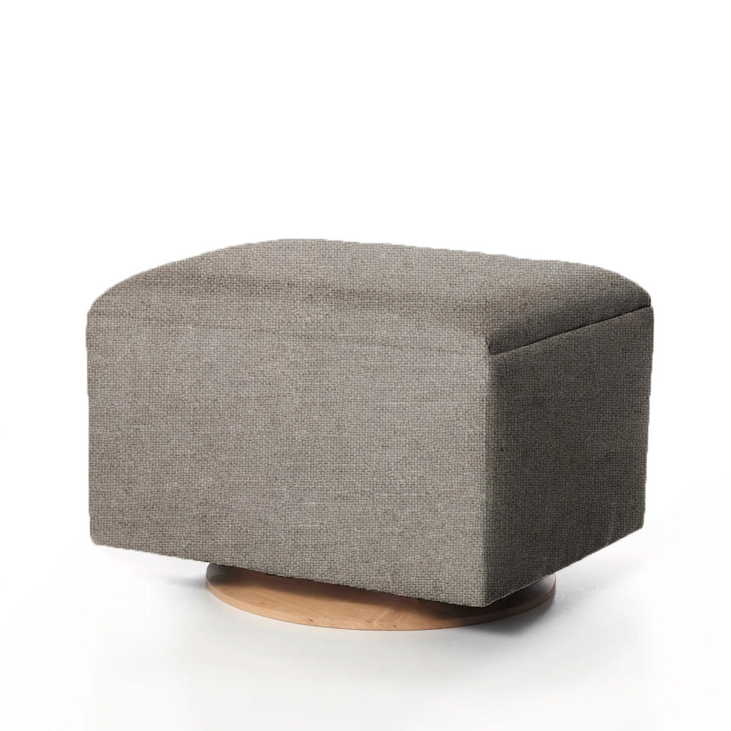 Gray-blue ottoman with soft fabric and round wooden base.