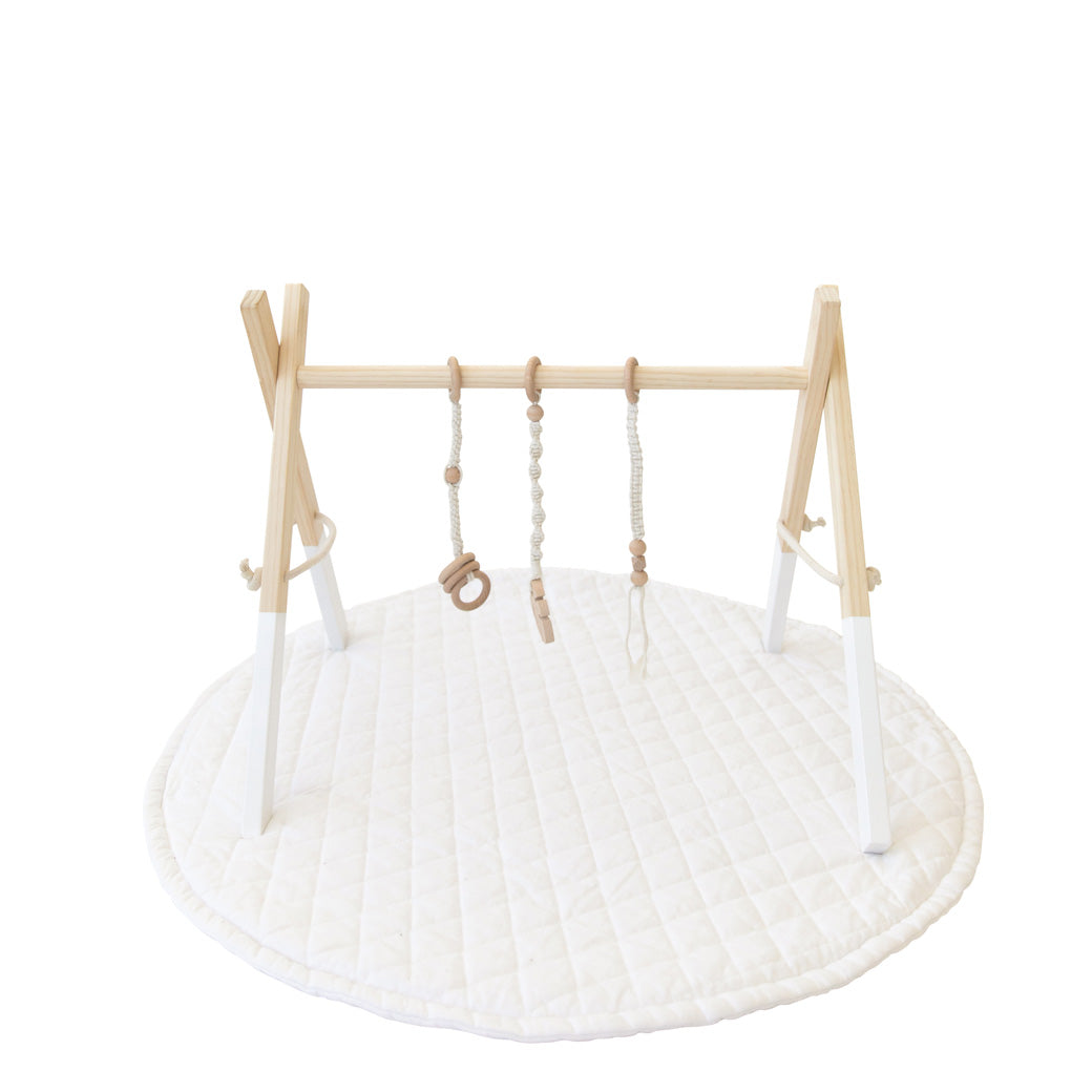 Poppyseed Play Wood Baby Gym + Toys on a mat in -- Color_White _ Macrame