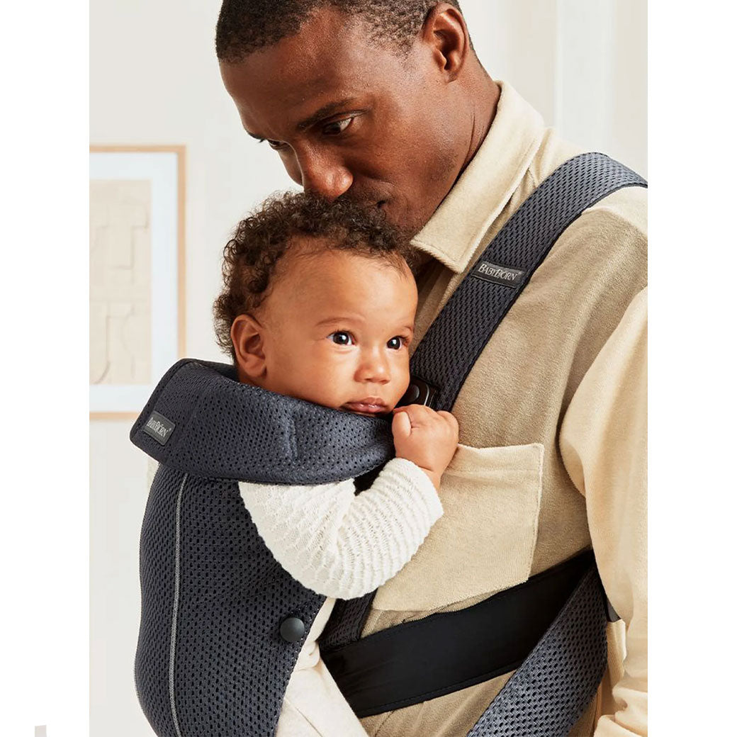 Dad kissing head of baby in BABYBJÖRN Baby Carrier Mini in -- Color_Anthracite (Slate Gray) 3D Mesh