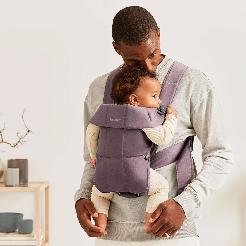 Dad holding baby in BABYBJÖRN Baby Carrier Mini with top part down in -- Color_Dark Purple Woven