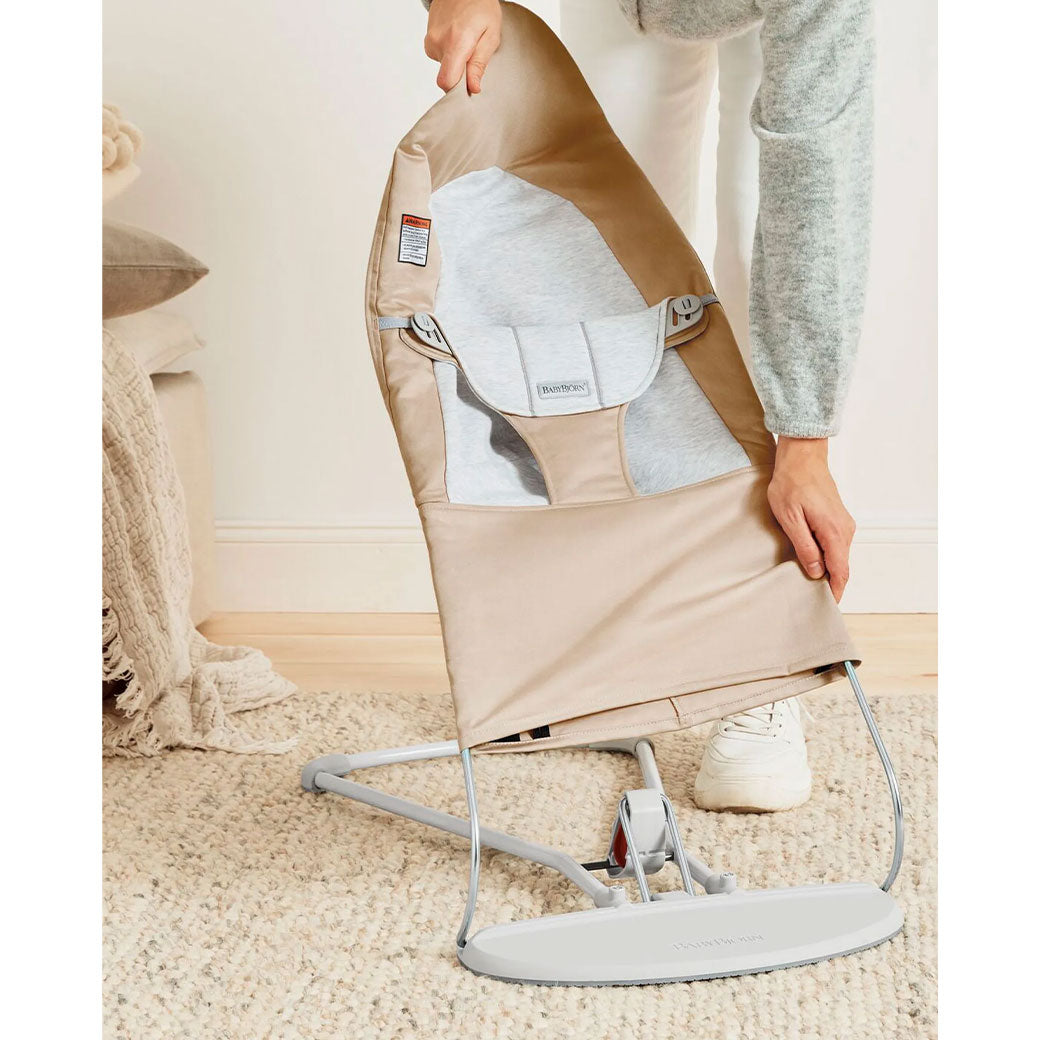 Mom taking cover off of BABYBJÖRN Bouncer Balance Soft in -- Color_Beige/Gray Woven/Jersey