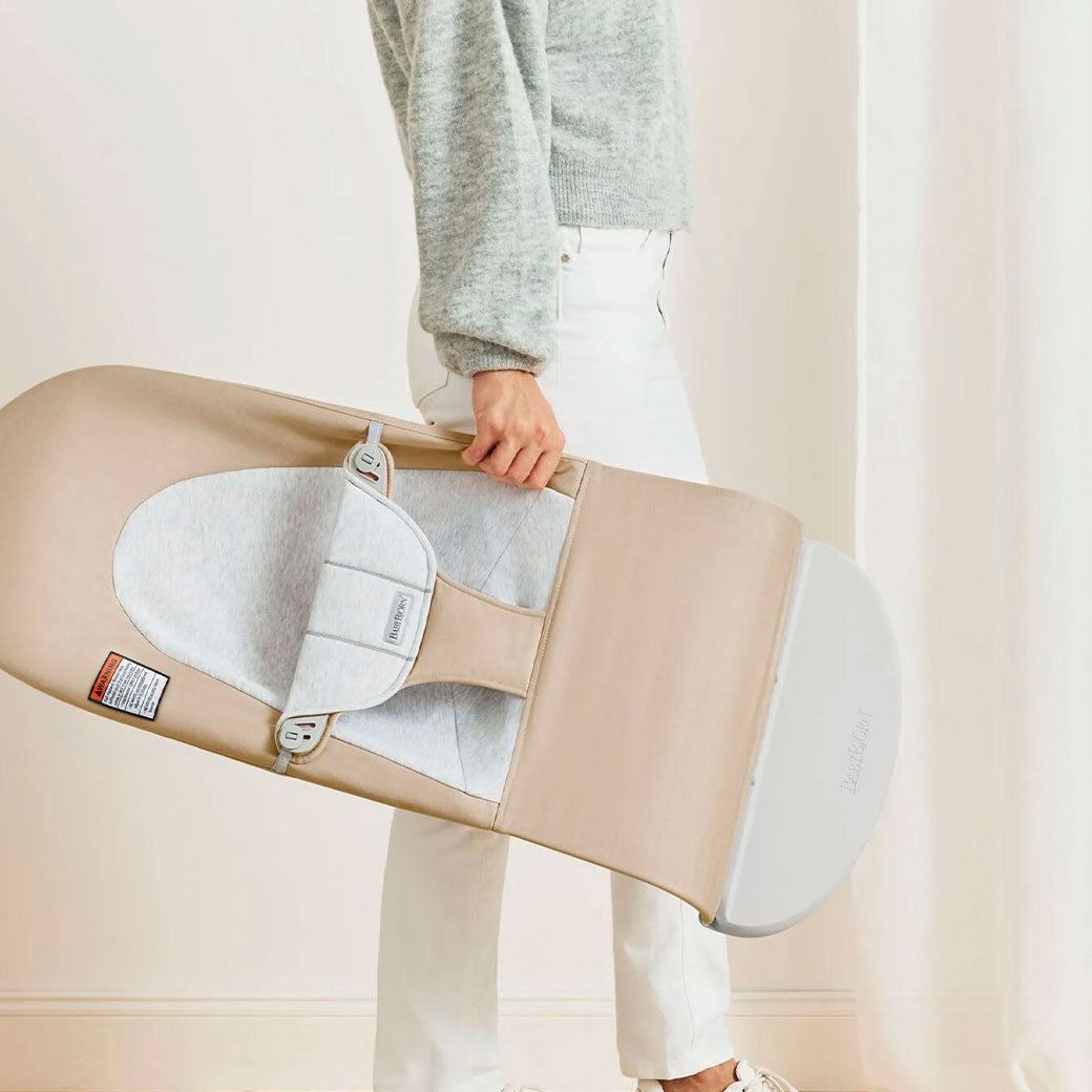 Mom carrying BABYBJÖRN Bouncer Balance Soft in -- Color_Beige/Gray Woven/Jersey