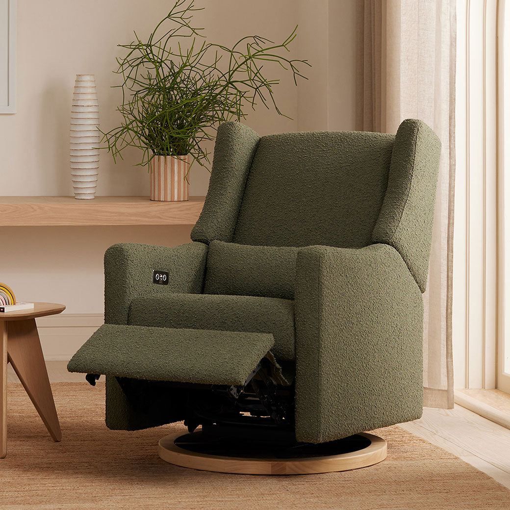 Babyletto Kiwi Glider Recliner with the footrest up next to a window and table  in -- Color_Olive Boucle With Light Base