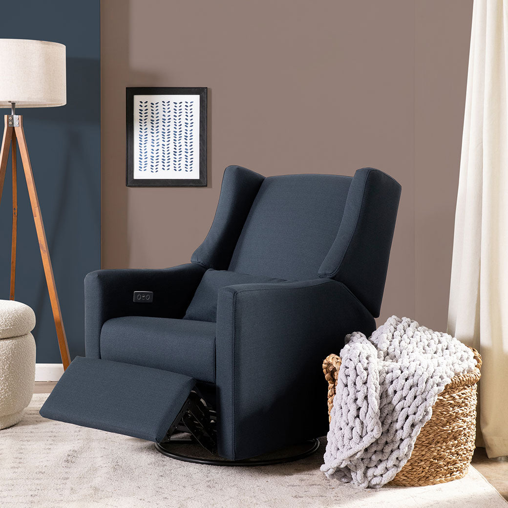 Babyletto Kiwi Glider Recliner with footrest up next to a basket  in -- Color_Performance Navy Eco-Twill