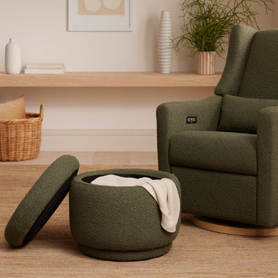 The Babyletto Enoki Storage Ottoman next to a recliner with a blanket inside  in --Color_Olive Boucle