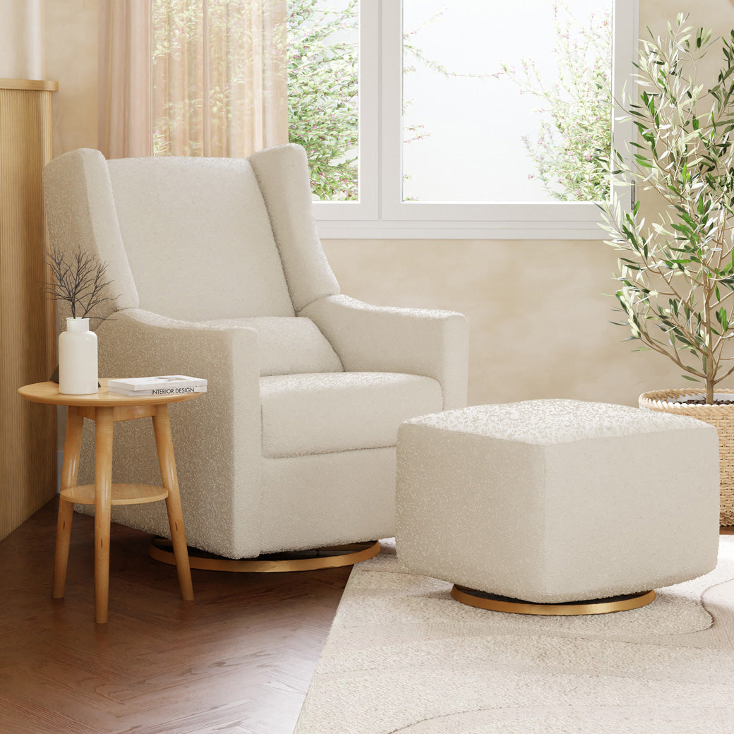 Babyletto Kiwi Glider Recliner next to an ottoman and window in -- Color_Ivory Boucle with Gold Base