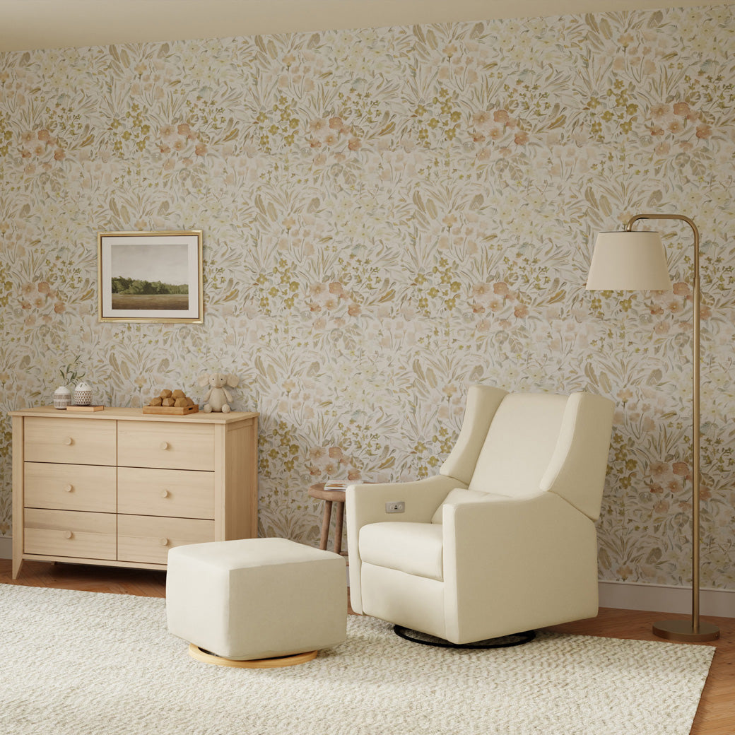 Babyletto Kiwi Glider Recliner next to an dresser, ottoman, and lamp  in -- Color_Performance Cream Eco-Weave