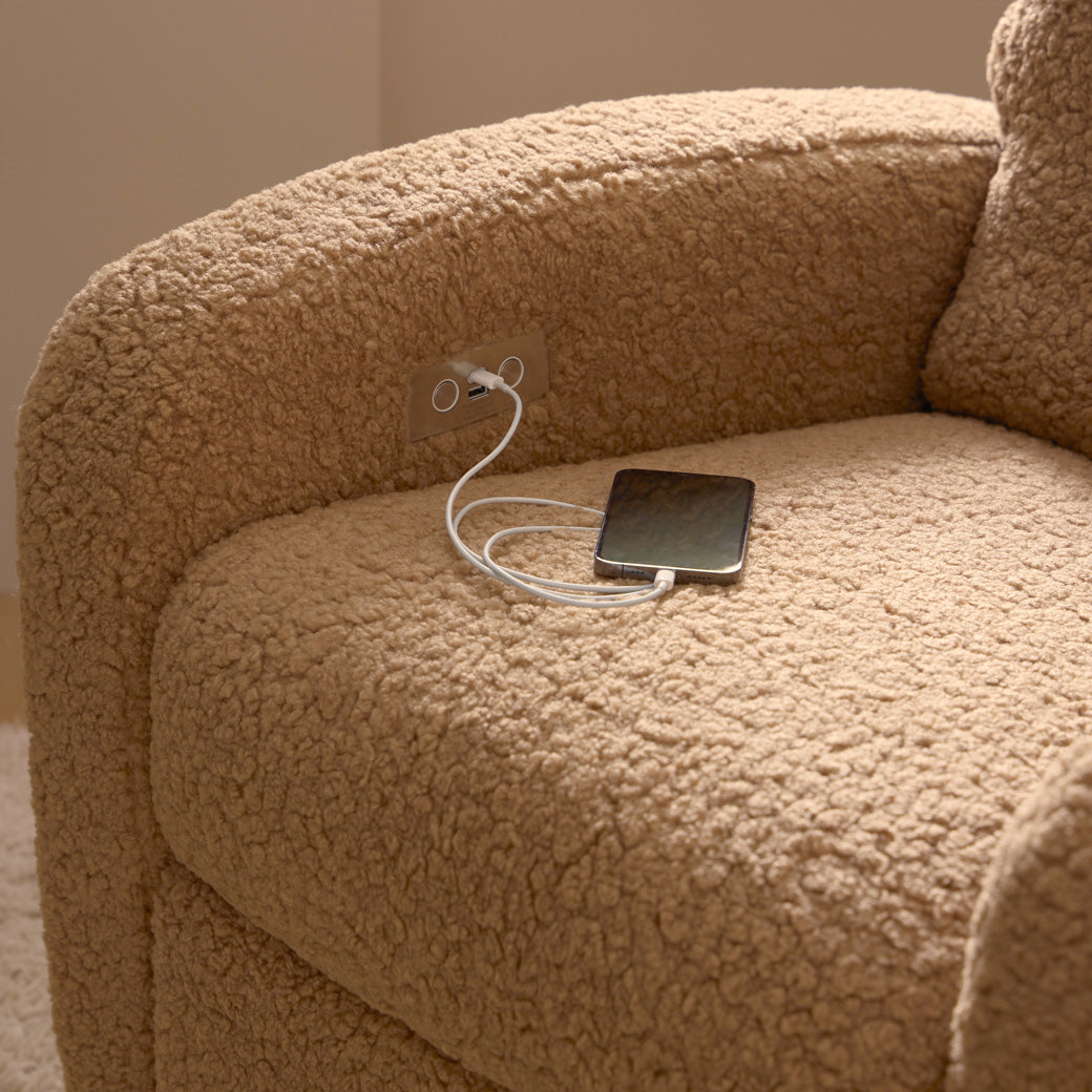 Closeup of phone charging on the Babyletto Nami Glider Recliner in -- Color_Cortado Shearling with Light Wood Base