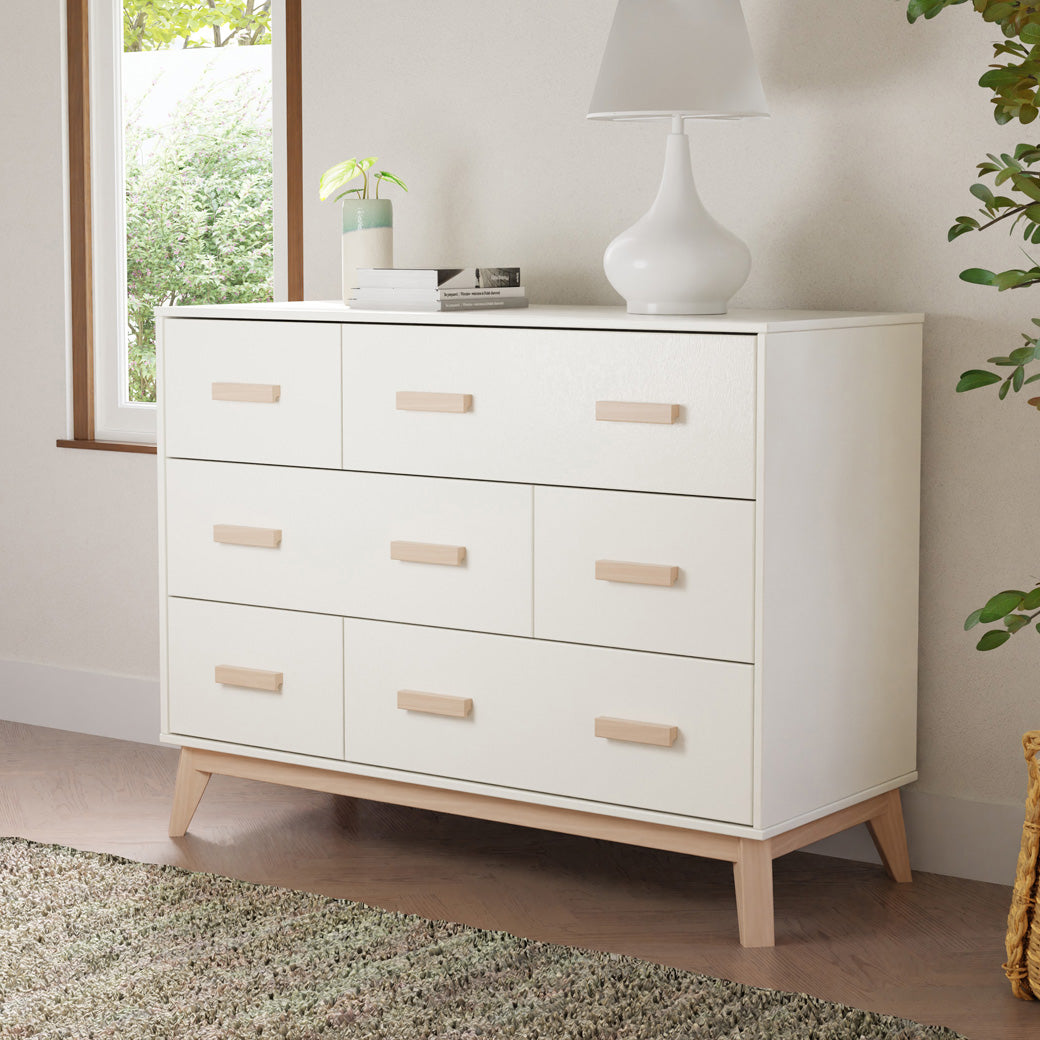 Babyletto Scoot 6-Drawer Dresser with a lamp and items on top in -- Color_White / Washed Natural