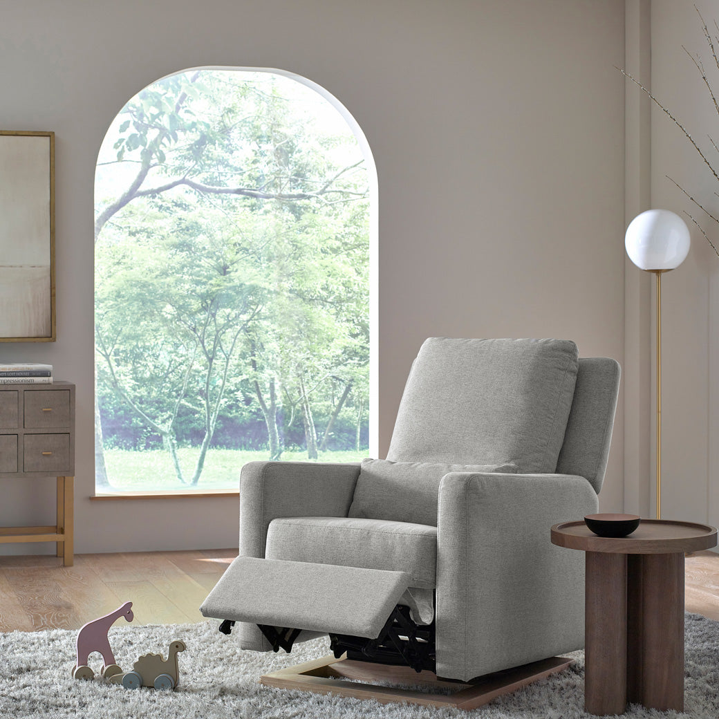 Babyletto Sigi Glider Recliner with footrest up next to a coffee table in -- Color_Performance Grey Eco-Weave with Light Wood Base