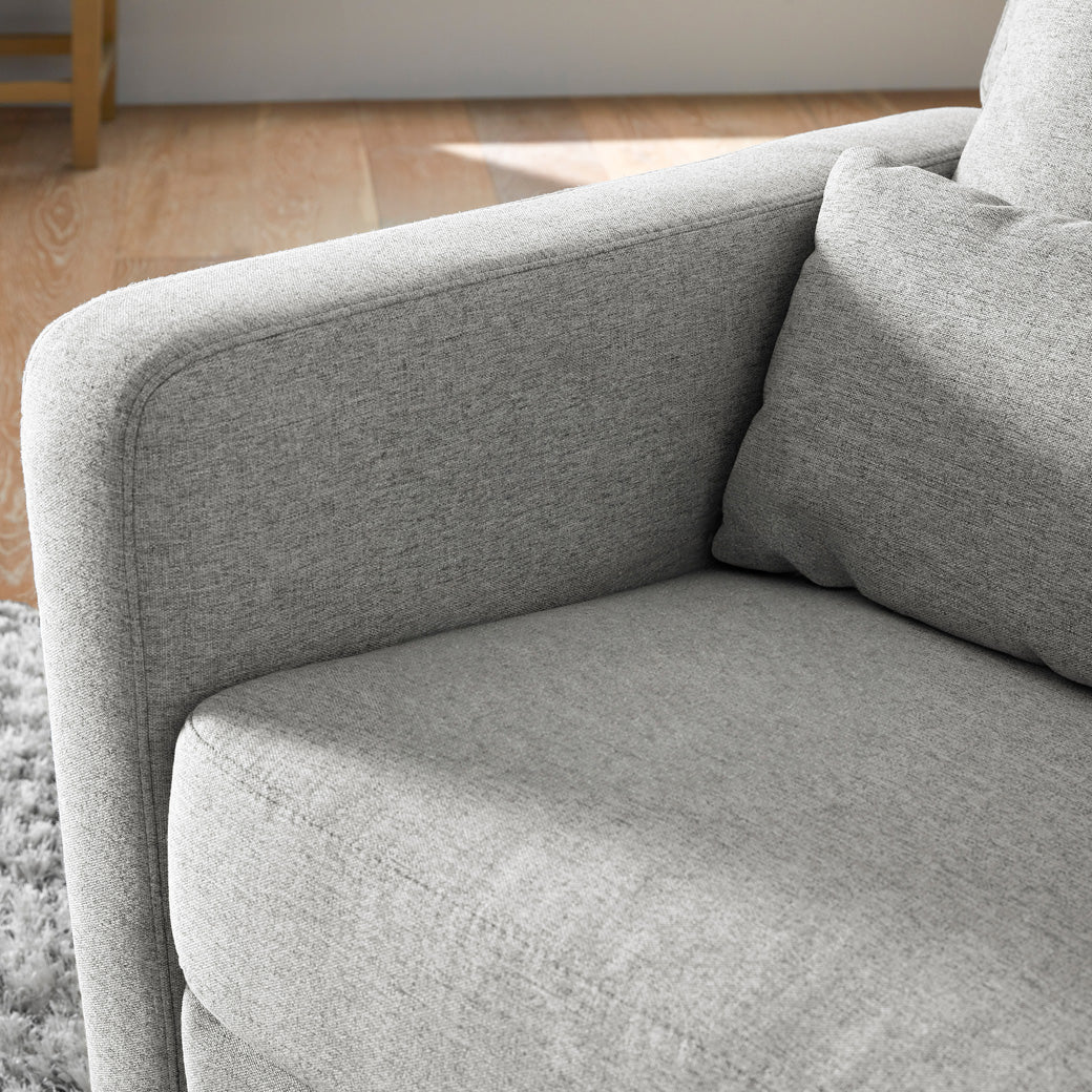Close up of the Babyletto Sigi Glider Recliner in a room  in -- Color_Performance Grey Eco-Weave with Light Wood Base