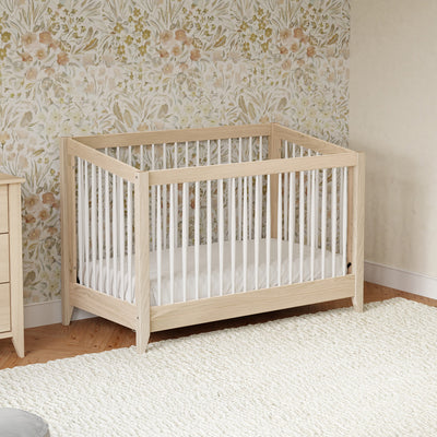 Babyletto's Sprout 4-in-1 Convertible Crib in a floral room  in -- Color_Washed Natural / White