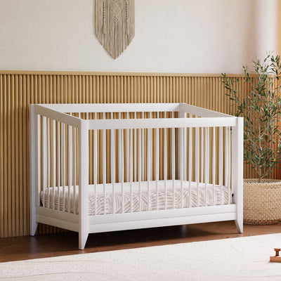 Babyletto's Sprout 4-in-1 Convertible Crib + Toddler Bed Conversion Kit next to a plant  in -- Color_White
