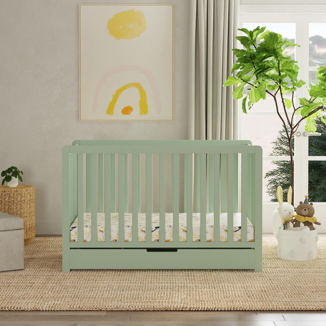 Front view of Carter's by DaVinci Colby 4-in-1 Convertible Crib with Trundle Drawer next to window and dresser  in -- Color_Light Sage