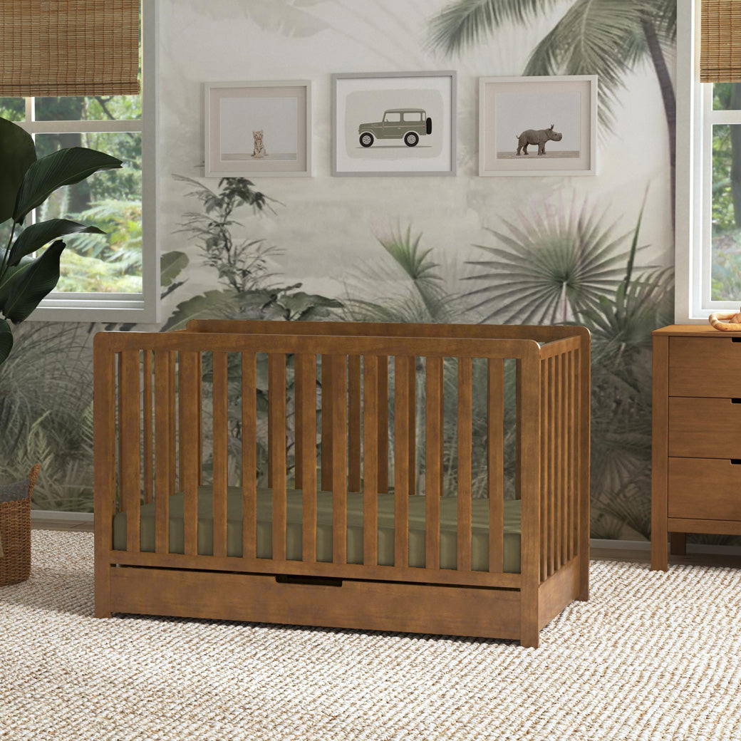 Carter's by DaVinci Colby 4-in-1 Convertible Crib with Trundle Drawer next to a dresser  in -- Color_Walnut