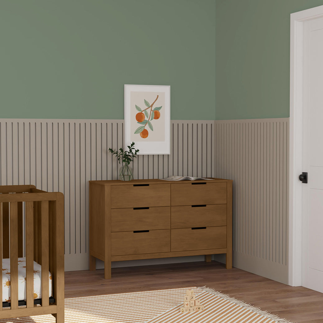 Carter's by DaVinci Colby 6-Drawer Dresser next to a crib  in -- Color_Walnut