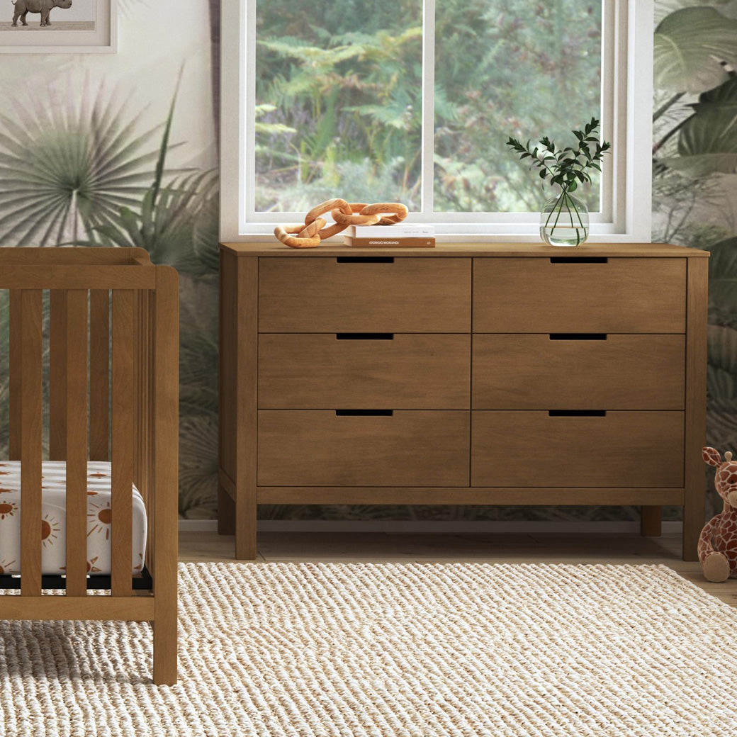 Carter's by DaVinci Colby 6-Drawer Dresser under a window and next to a crib in -- Color_Walnut
