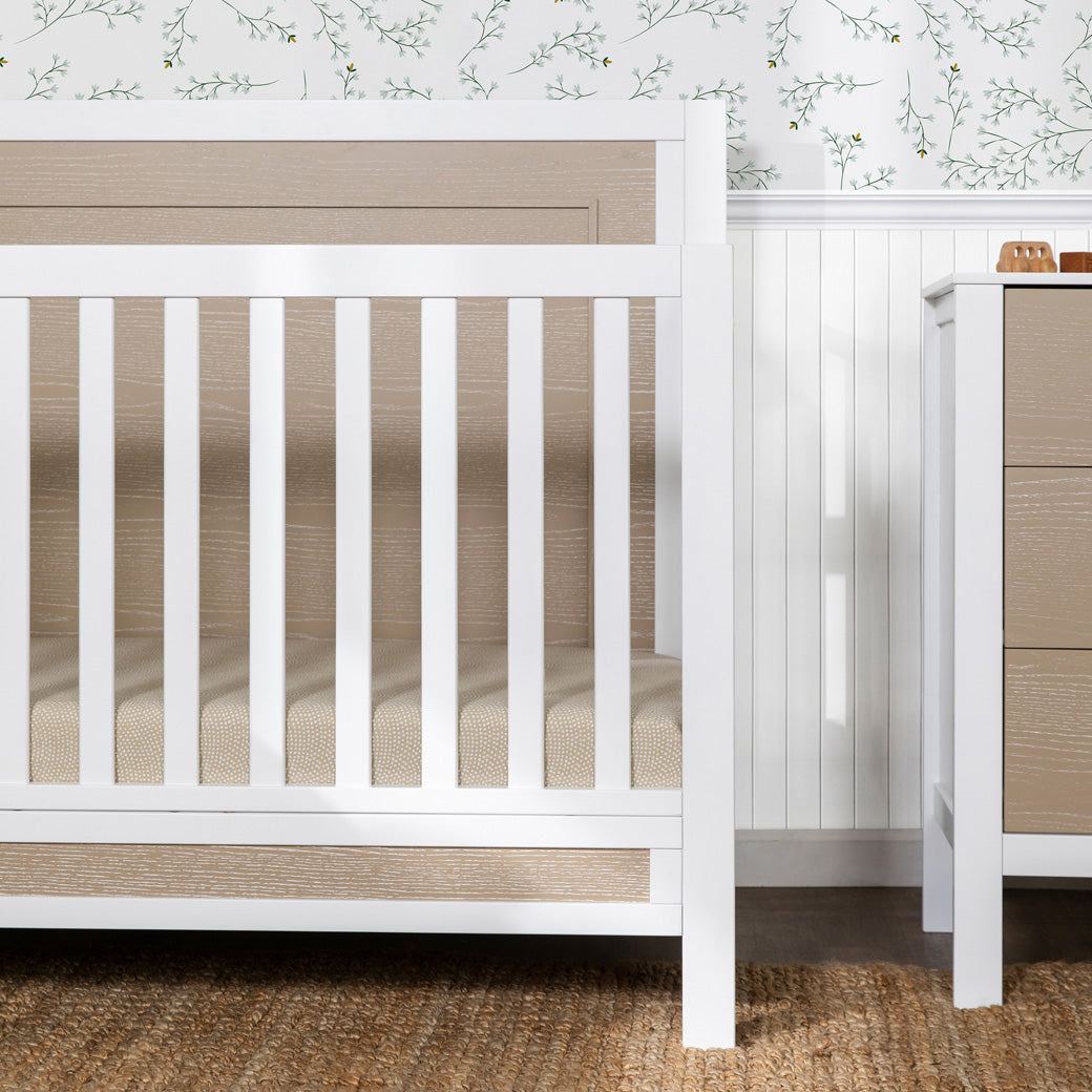Right side closeup of Carter's by DaVinci Radley 4-in-1 Convertible Crib in next to a dresser -- Color_White/Coastwood