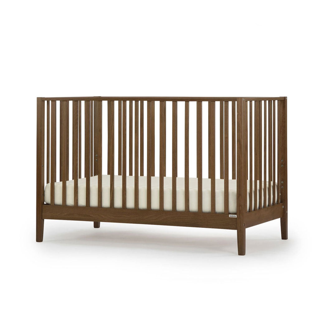 Angled view of Dadada Lala 3-in-1 Convertible Crib in - Color_Walnut