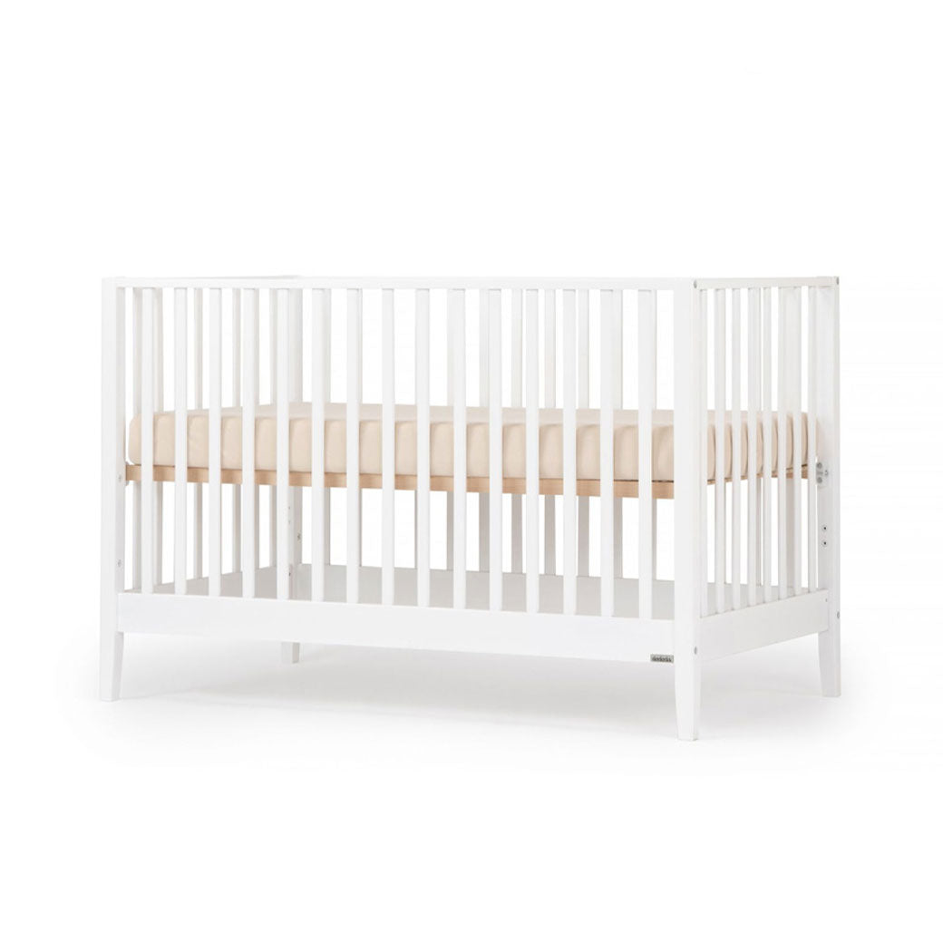 Angled view of Dadada Lala 3-in-1 Convertible Crib in - Color_White
