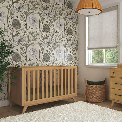 DaVinci Otto 3-in-1 Convertible Crib next to a window, basket, and dresser  in -- Color_Honey _ Wood