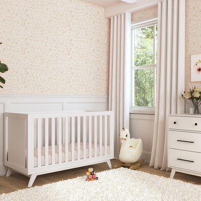 DaVinci Otto 3-in-1 Convertible Crib  next to a window and dresser in -- Color_White _ Wood