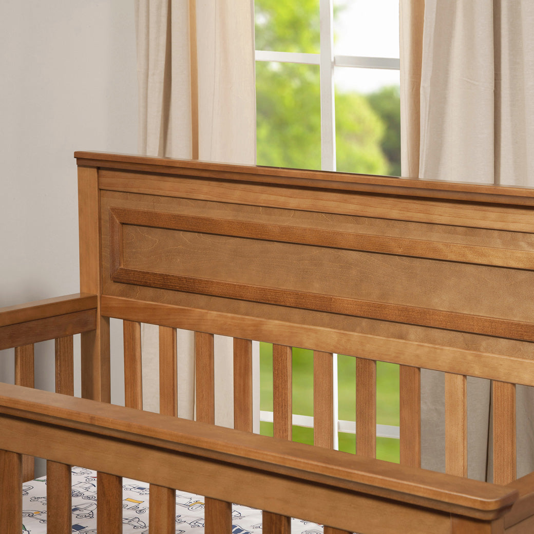 DaVinci Autumn 4-in-1 Convertible Crib  in front of the window in -- Color_Chestnut