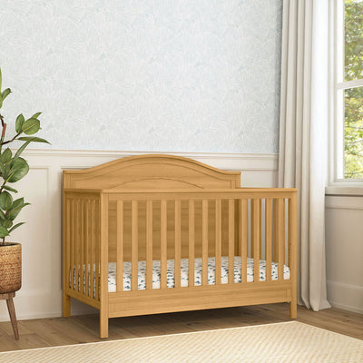 The DaVinci Charlie 4-in-1 Convertible Crib next to a window  in -- Color_Honey