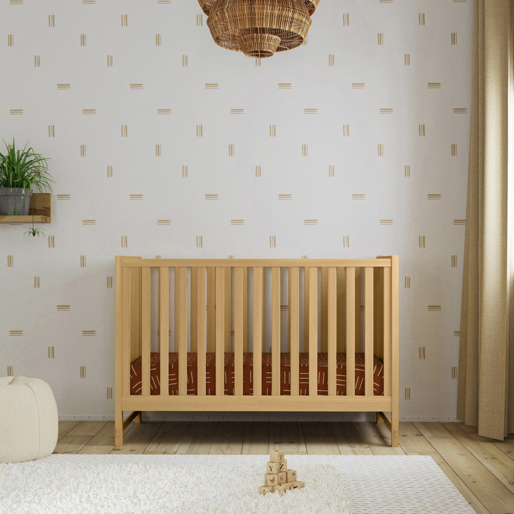 Front view of DaVinci Margot 3-in-1 Convertible Crib next to a window  in -- Color_Honey