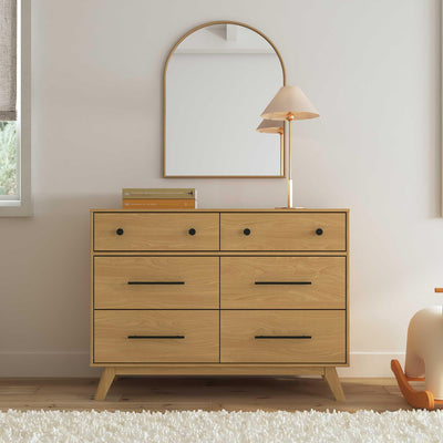 Front view of DaVinci Otto 6-Drawer Dresser under a mirror and a lamp on top  in -- Color_Honey