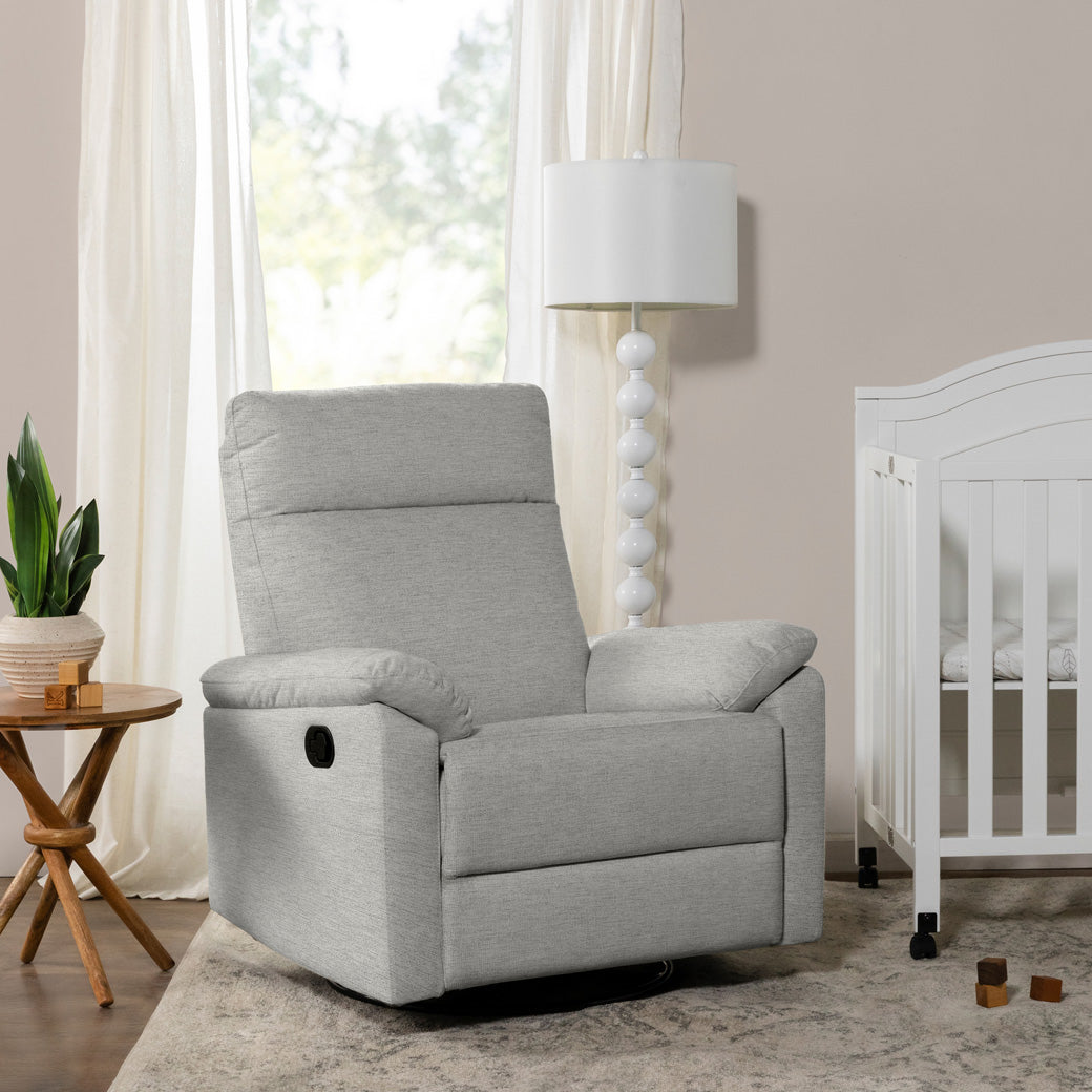 DaVinci Suzy Recliner and Swivel Glider next to a lamp and crib  in -- Color_Frost Grey