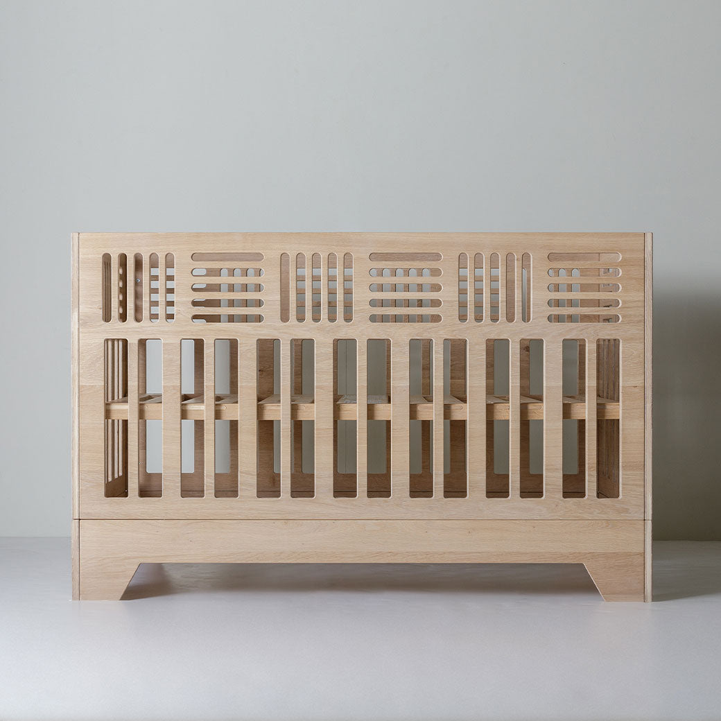 Front view of Kalon Io Crib with slats for the mattress positioned in the middle -- Lifestyle