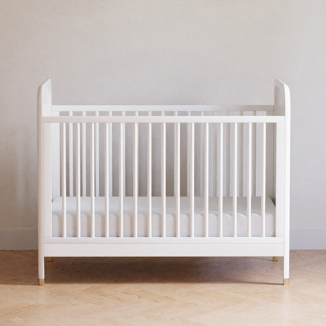 Front view of Namesake Brimsley 3-in-1 Convertible Crib in a white-wall room in -- Color_Warm White