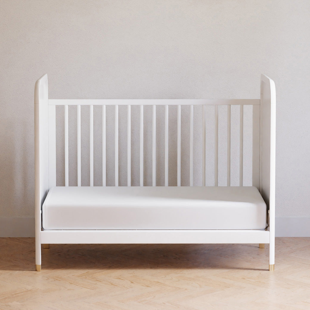 Front view of Namesake Brimsley 3-in-1 Convertible Crib as a daybed in a white-wall room  in -- Color_Warm White