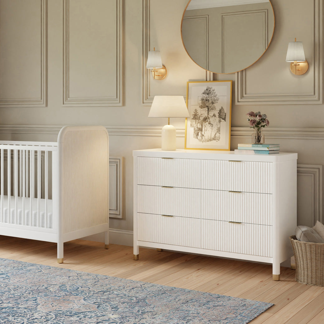 Namesake Brimsley 6-Drawer Dresser next to a crib in -- Color_Warm White