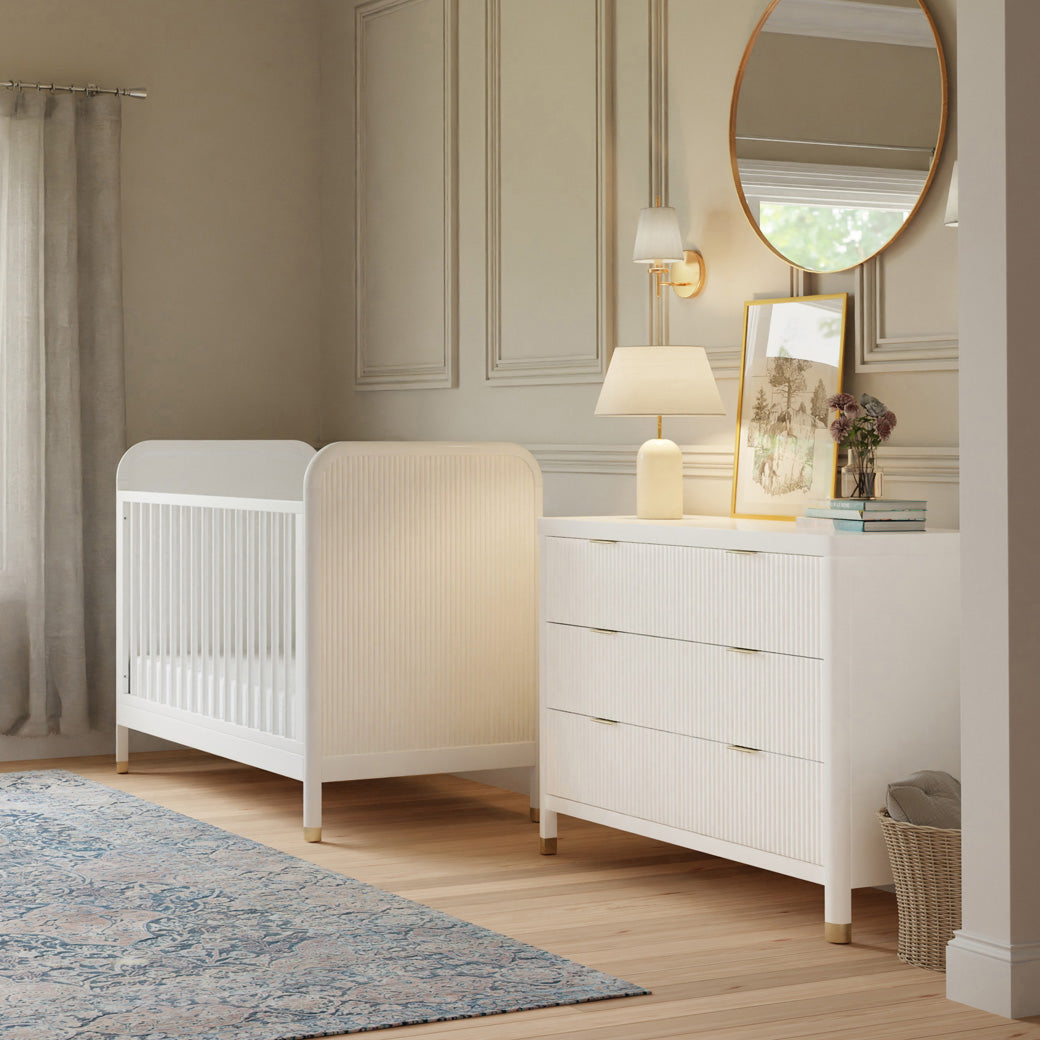 Side view of Namesake Brimsley 6-Drawer Dresser next to a crib in -- Color_Warm White